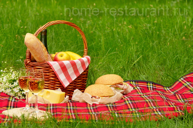 Семейный пикник: Корзина с едой, плед, гамбургеры и бокалы с вином на зеленой траве